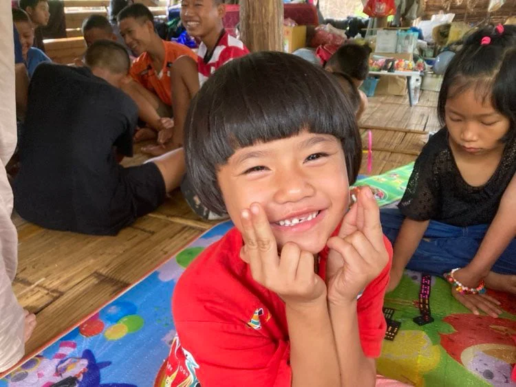 Smiling refugee child at Mae Sot school learning arts and crafts. Supporting refugee child education Thailand through the Back to School Project.